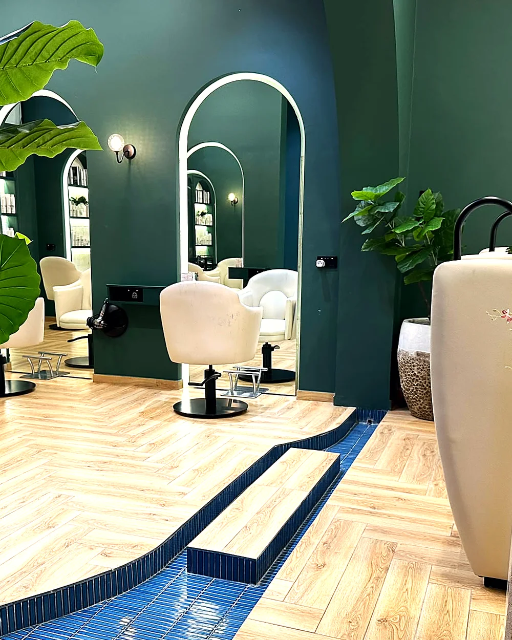 The styling floor at Promise Hair Concept — arched mirrors, cream chairs and the blue mosaic inlay
