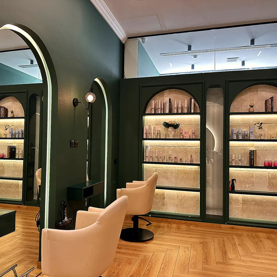 Backlit product shelves set into the travertine wall